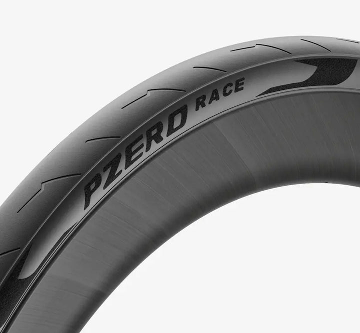 Close-up of a Black Pirelli PZero Race tire with detailed tread pattern on a white background - Dragonspine Cycling