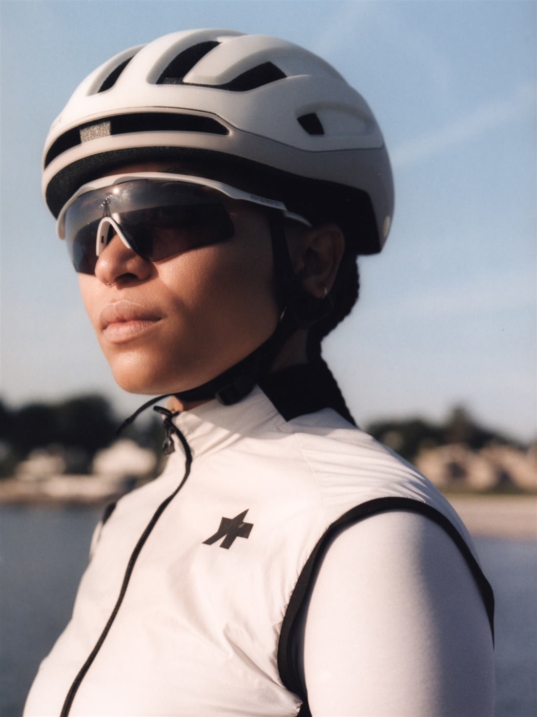 Rider in a white Assos vest and helmet by the sea
