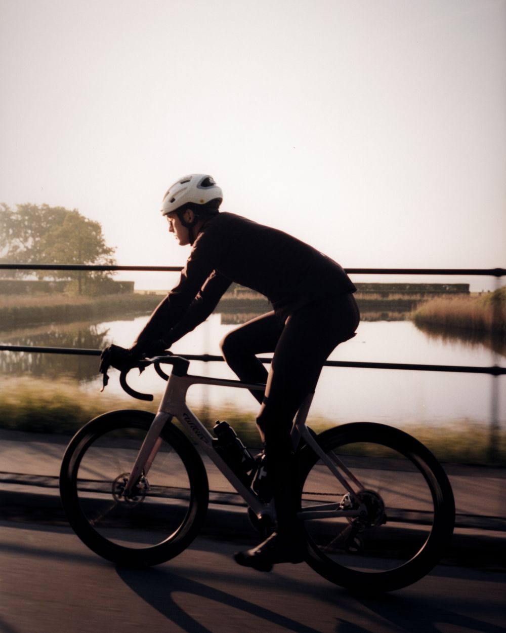 Rider crossing a bridge at sunset