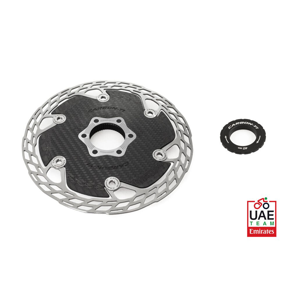 Carbon fiber disc brake rotor with a small washer on a white background, featuring the UAE Team Emirates logo.